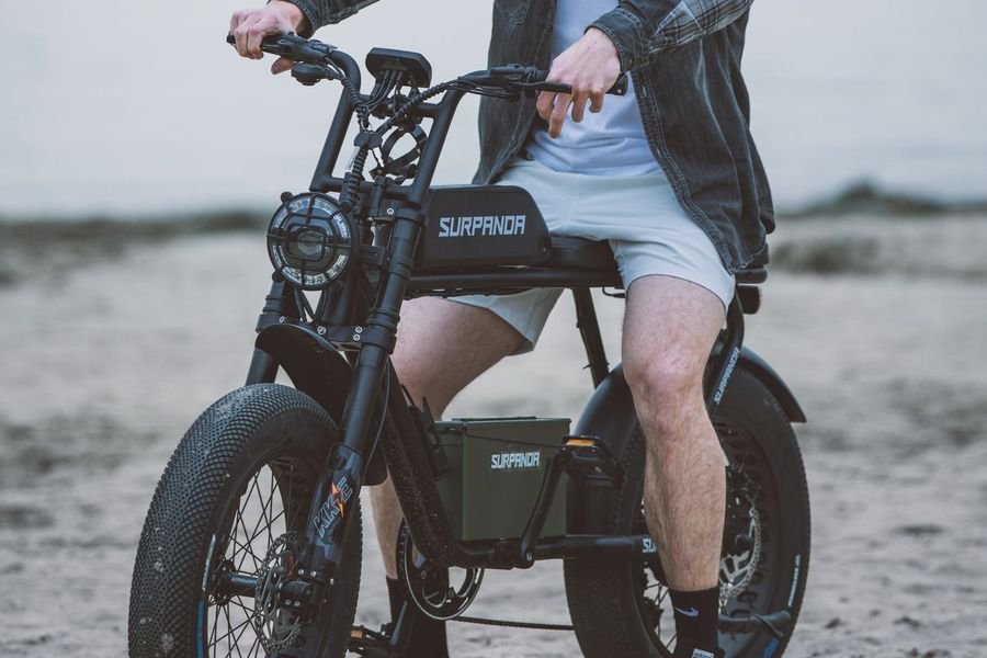 Rider on a fat-tire electric bike on a sandy lakeside beach